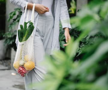 woman with a net with fresh fruits and vegetables